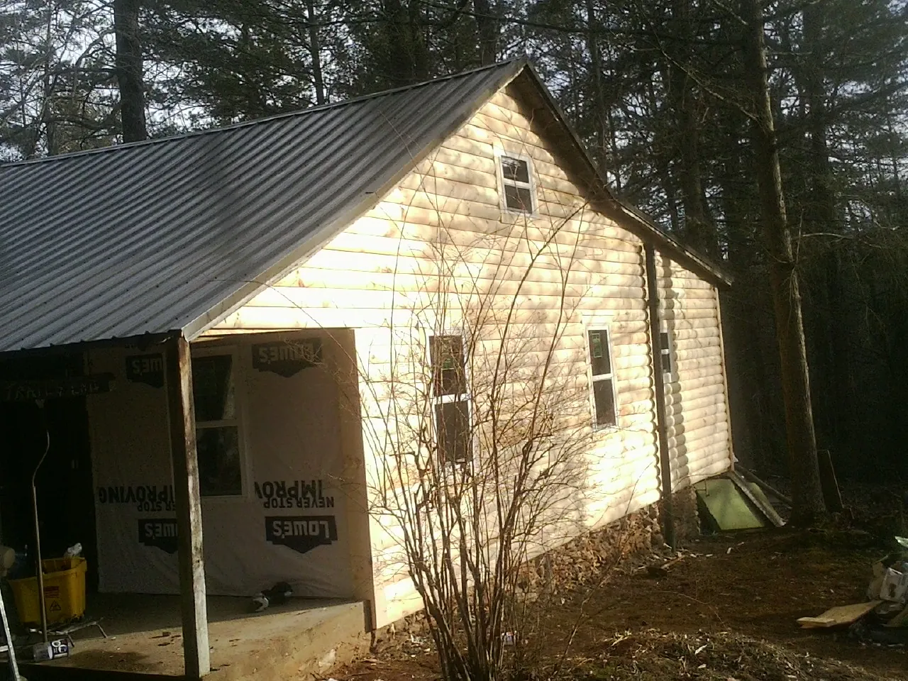 Log siding gable end under a dark metal roof edge in Eastover