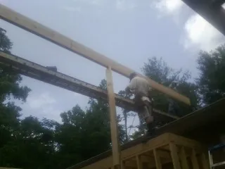 Carpenter setting a ridge beam over a new addition frame — Ice Dam Removal by Roofing Brothers in Eastover