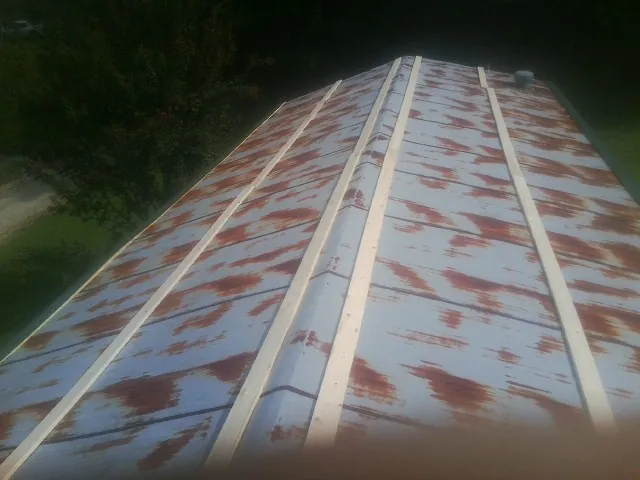 Rusted metal roof panels with new wood purlins before replacement — Storm Damage Roof Repair in Eastover by Roofing Brothers