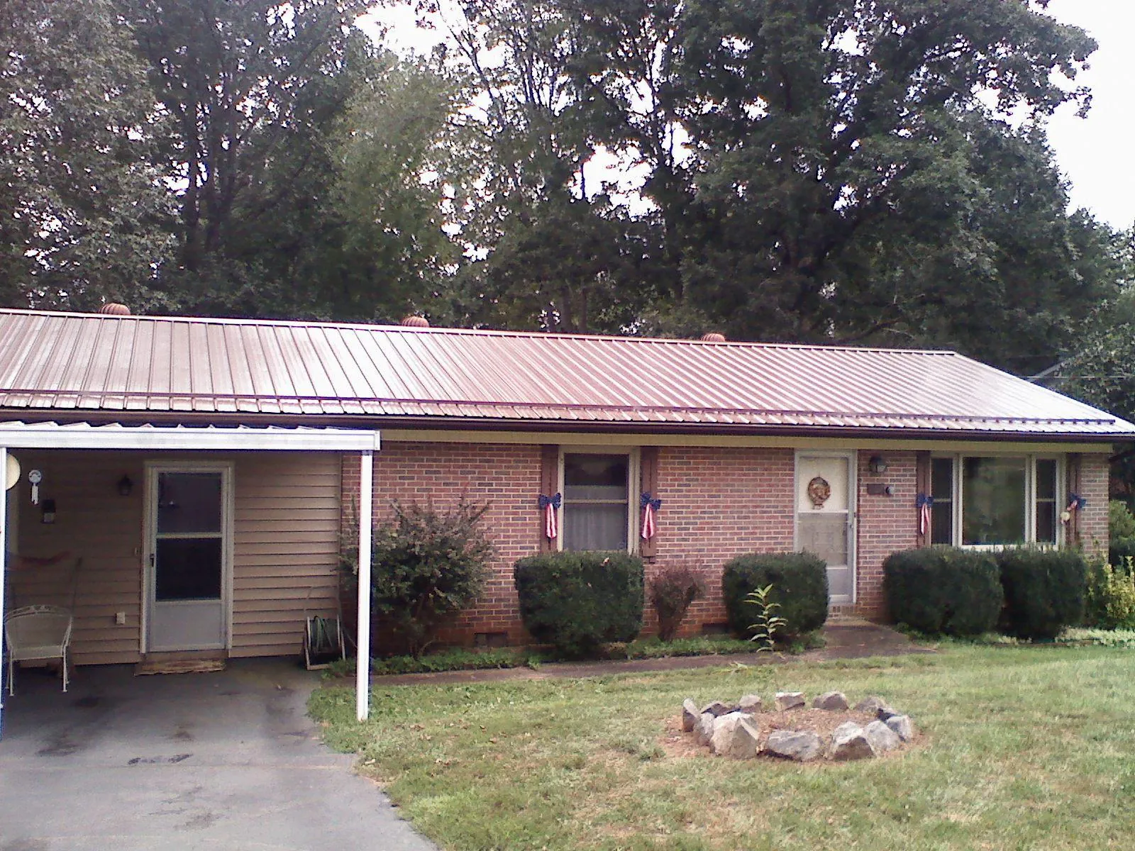 Bronze metal roof and carport on a brick ranch home — Roof Repair work by our crew in Eastover