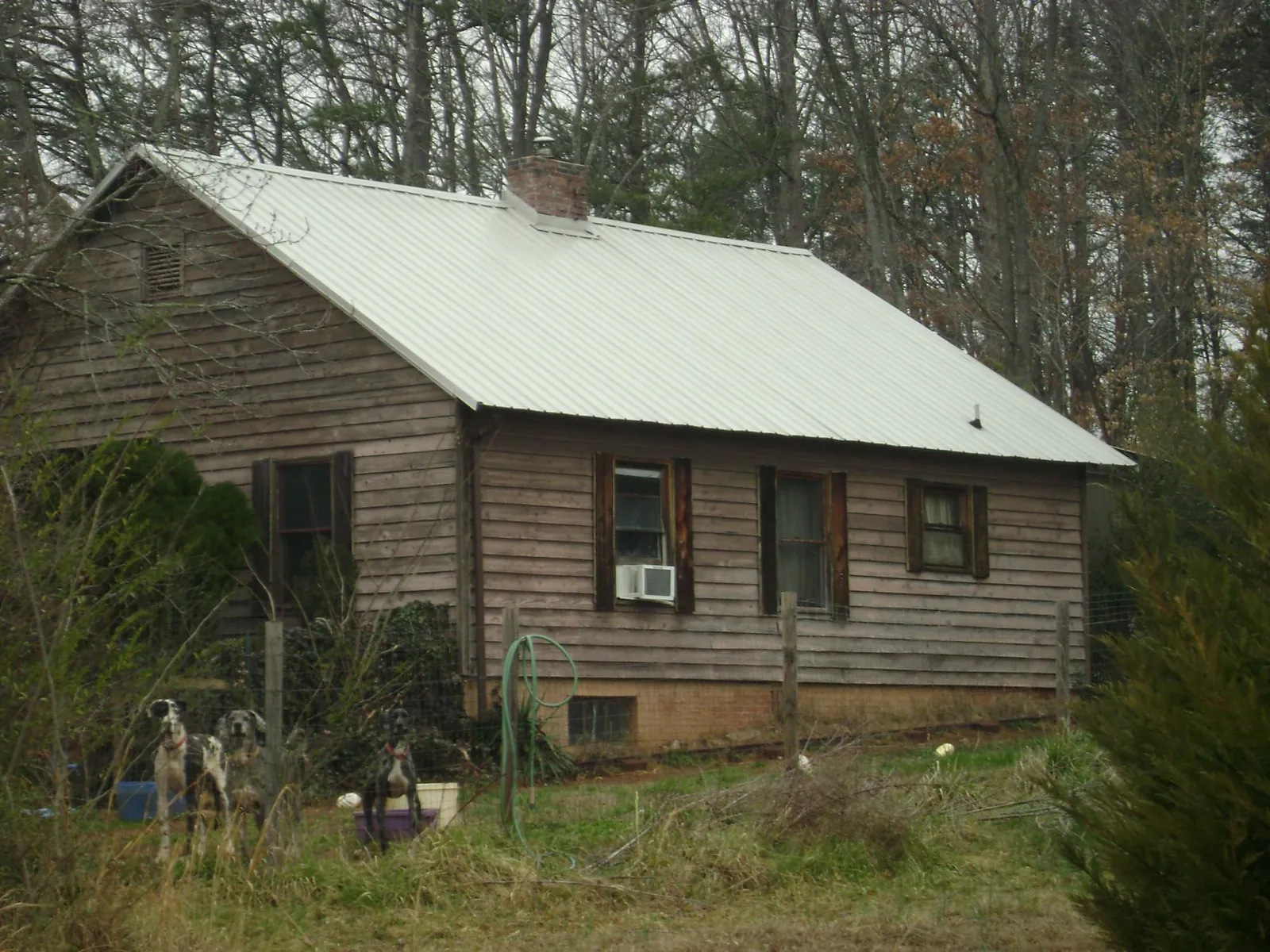 White metal roof on an old wood sided farmhouse, from a Metal Roof Installation job in Eastover